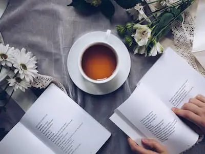cup of tea with book and flowers